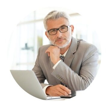 Man in suit thinking at laptop.